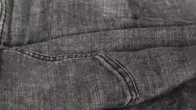 Black Denim Fabric Texture Background with Crumpled Wrinkled Cotton Jeans Surface