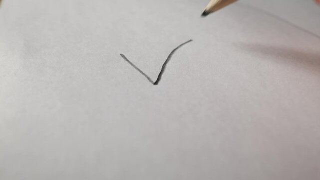A sharp color pencil tip touches the surface of a blank white sheet of paper in a close-up view. Concept of creativity, education, beginning a new project, and artistic expression.