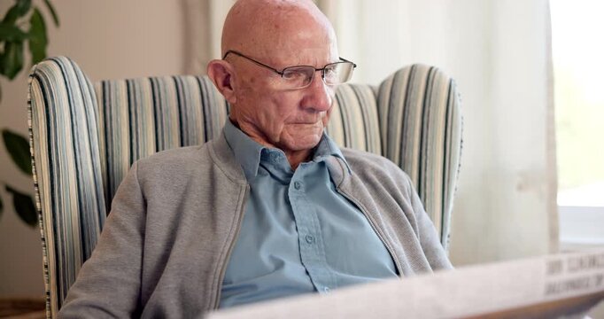 Newspaper, reading and relax with old woman in living room of home for break or information. Article, glasses and retirement with senior person on chair in apartment for media publication or report