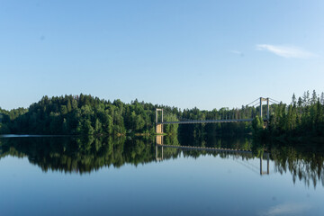 Obraz premium Vamma Bridge spanning Glomma river reflecting forest