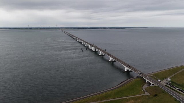 Zeeland bridge crossing the oosterschelde sea with traffic and windmills