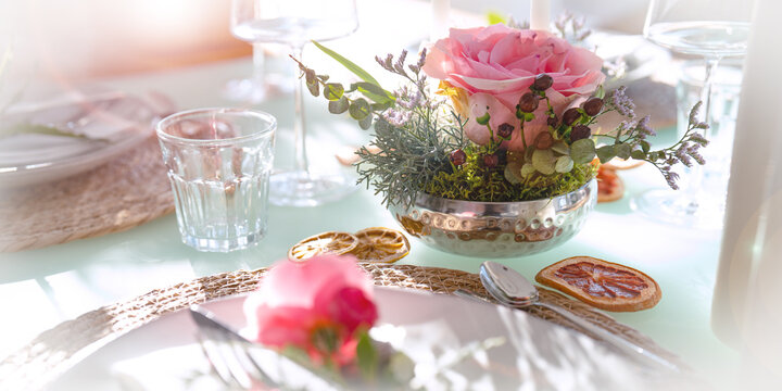 Romantic wedding table decoration. Special event table setting. Arrangement with fresh pink roses. Close-up with short depht of field.