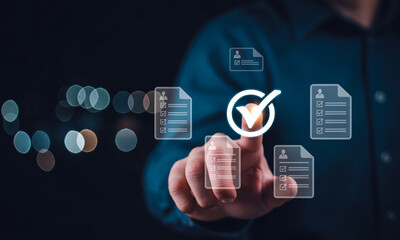 Fototapeta premium Businessman working on laptop with virtual screen, document with checkbox and checkmark, online survey, checklist concept.