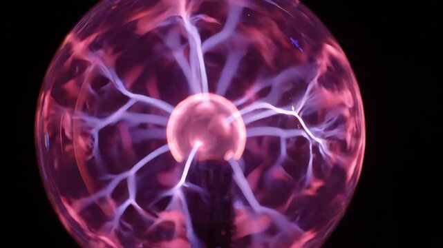 Plasma ball glowing with electric lightning bolts on dark background for science and technology content