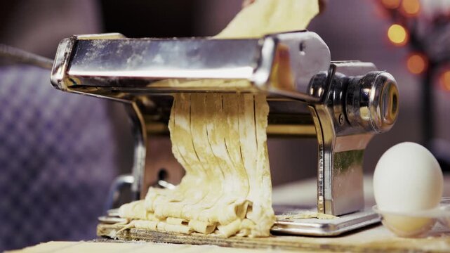 Cutting Fresh Raw Dough Into Noodles With Manual Metal Pasta Machine. Italian Cooking