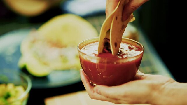 Dipping Corn Taco Into Red Tomato Salsa Sauce Bowl. Mexican Food 