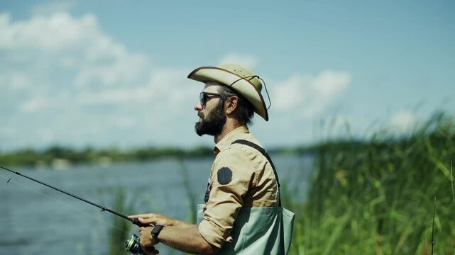 Fisherman Holding Spinning Rod Fishing On River Bank. Outdoor Recreation. Summer Hobby 