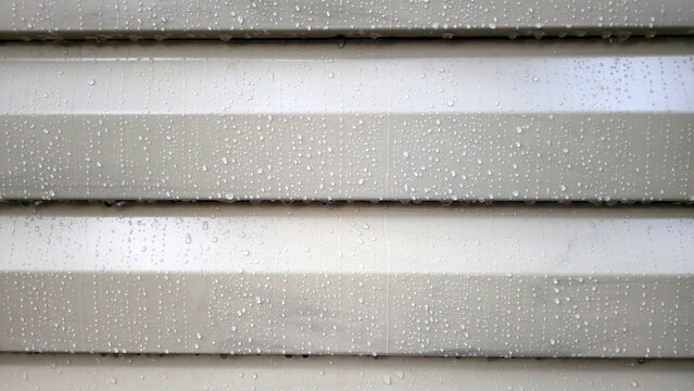 Minimalistic wet facade vinyl siding texture background covered with raindrops, simple elegant abstract background