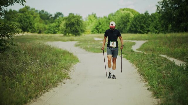 Athlete Nordic Walking On Rural Dirt Path.  Competition With Trekking Poles