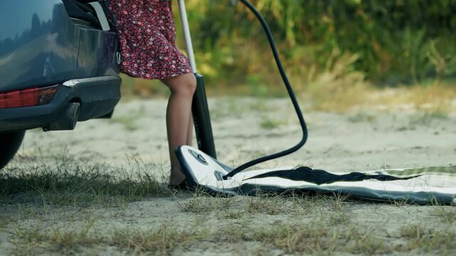 Person Pumping Inflatable Stand Up Paddle Board Near Car Trunk. Outdoor Active Recreation
