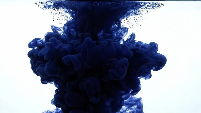 Dark blue ink dissolving and spreading in water on white background for abstract art content
