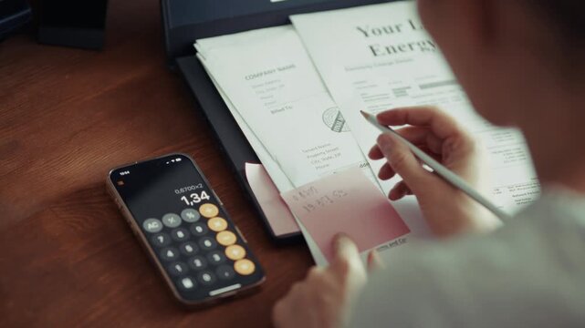 Person Writing Numbers On PaperAnd  Calculating Utility Expenses. Budget Planning 