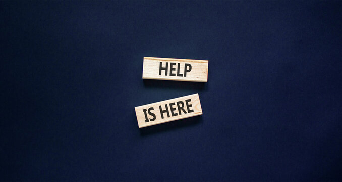 Help is here and support words symbol. Concept words Help is here on beautiful wooden blocks. Beautiful black background. Business help is here and support concept. Copy space.