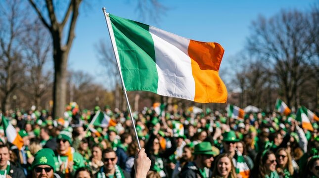 St. Patrick's Day celebration featuring a close-up of the Ireland flag held against a sunny sky.
