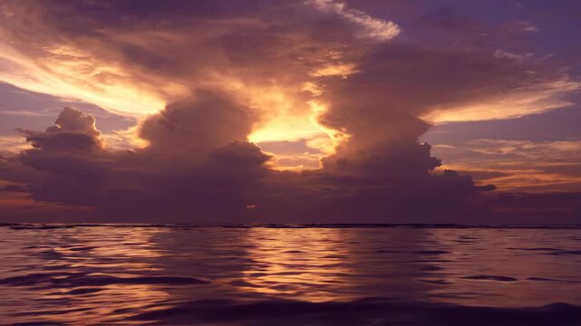 Dramatic sunset clouds glowing over calm ocean water for nature and travel content
