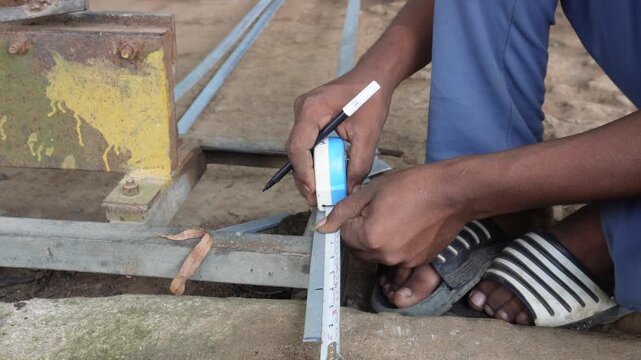 Worker measuring steel bar for precise