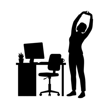 Woman silhouette stretches her arms beside a modern office desk and computer workstation setup.
