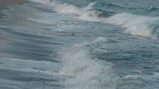 Powerful waves crashing onto a sandy beach