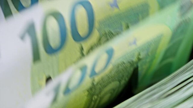 Euro banknotes rapidly counted by an automatic cash counter. Inflation, purchasing power, rising prices, household budgets and European economic challenges.