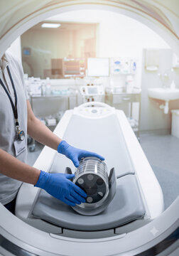 Technician placing CT phantom on scanner table for calibration