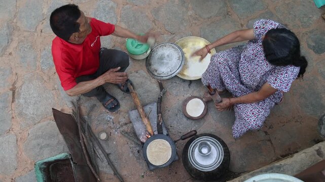 Raw video footage of village women making traditional roti outdoors in Uttarakhand, India, showcasing authentic rural cooking, village life, and poverty.
