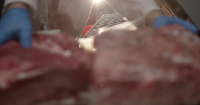 Vacuum packed beef moves along a roller conveyor in a plant