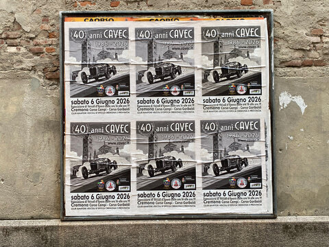 Vintage car posters advertising CAVEC 40th anniversary exhibition in Cremona, Italy, on a brick wall