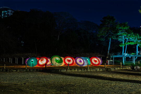 Beautifully illuminated traditional Japanese umbrellas (wagasa) lined up at night in Koishikawa Korakuen January 2024