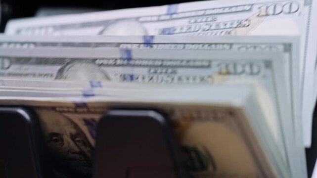 US dollar banknotes counted by automatic machine before currency exchange. Foreign exchange, international finance, travel money, exchange office and global business concept.