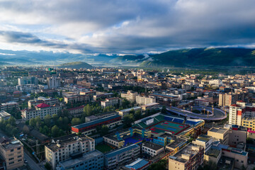 Obraz premium Aerial panoramic view of Garzê County at sunrise, Tibetan town by Yalong River, Garzê Temple white stupa, mountain plateau city morning landscape in West Sichuan