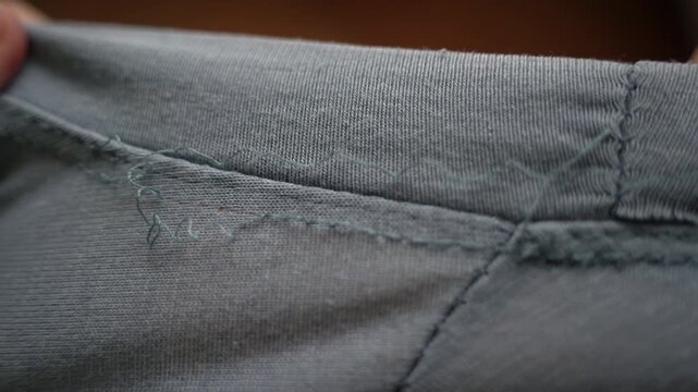 Close-Up of T-Shirt Falling Apart at Seams &ndash; Stitches Unraveling and Fabric Damage