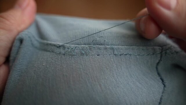Close-Up of T-Shirt Falling Apart at Seams &ndash; Stitches Unraveling and Fabric Damage