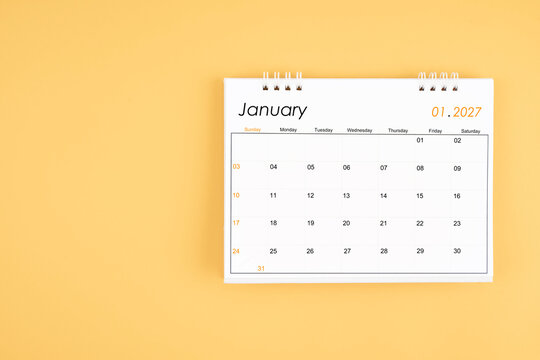 January 2027 desk calendar on yellow color background, position with copy space.