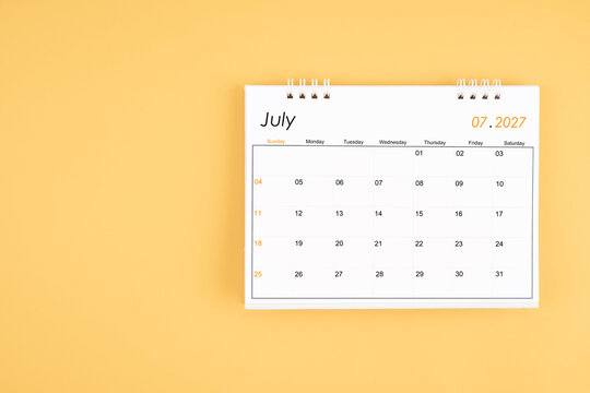 July 2027 desk calendar on yellow color background, position with copy space.