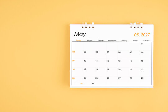 May 2027 desk calendar on yellow color background, position with copy space.