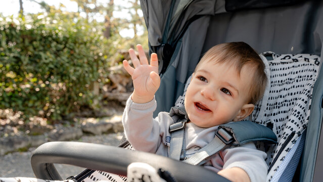 Smiling baby outdoors in stroller at historic temple