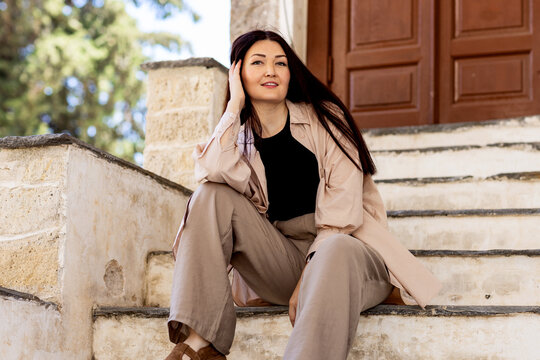 Woman relaxing on stone steps outside a building entrance