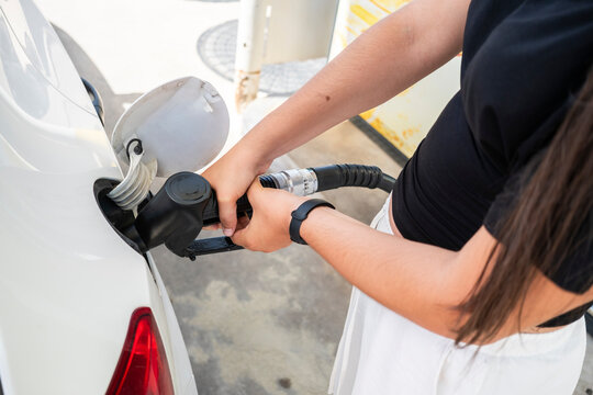 Woman refueling car with diesel fuel at gas station