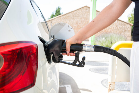 Woman refueling a car with diesel at a gas station