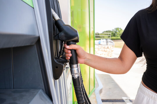 Woman refueling car with diesel fuel at gas station
