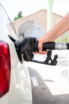 Woman refueling car with diesel nozzle at gas station