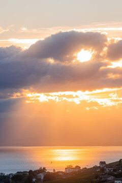 Golden sunset over Lake Geneva with clouds and rays