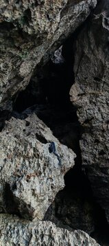 Dramatic Limestone Rock Crevice Revealing Natural Cave Formation and Rugged Coastal Geological Texture in Parangtritis Beach Indonesia