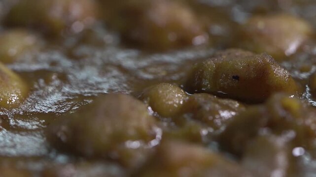Extreme close up shot of authentic Amritsari chole showcasing rich gravy and chickpea texture.