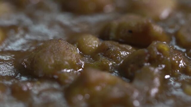 Extreme close up shot of authentic Amritsari chole showcasing rich gravy and chickpea texture.