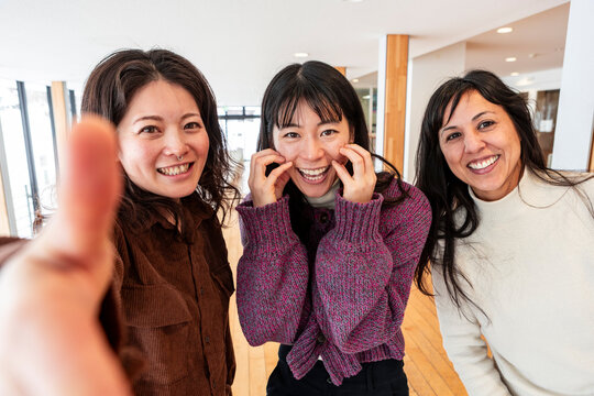 Group of japanese women smiling in a bright indoor space