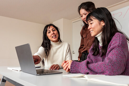 Adult Japanese lesson with tutor using laptop in classroom