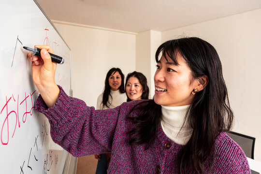Adult Japanese lesson with teacher writing hiragana