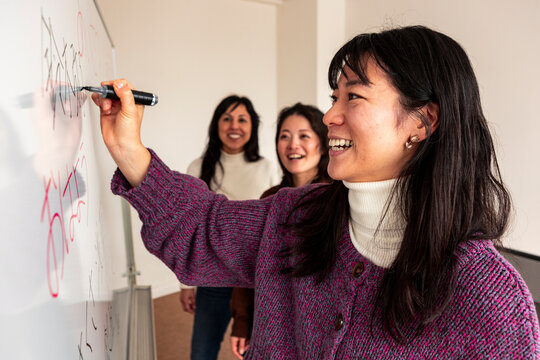 Adult Japanese lesson with teacher writing on whiteboard
