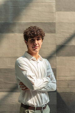Young professional portrait with arms crossed in sunlight